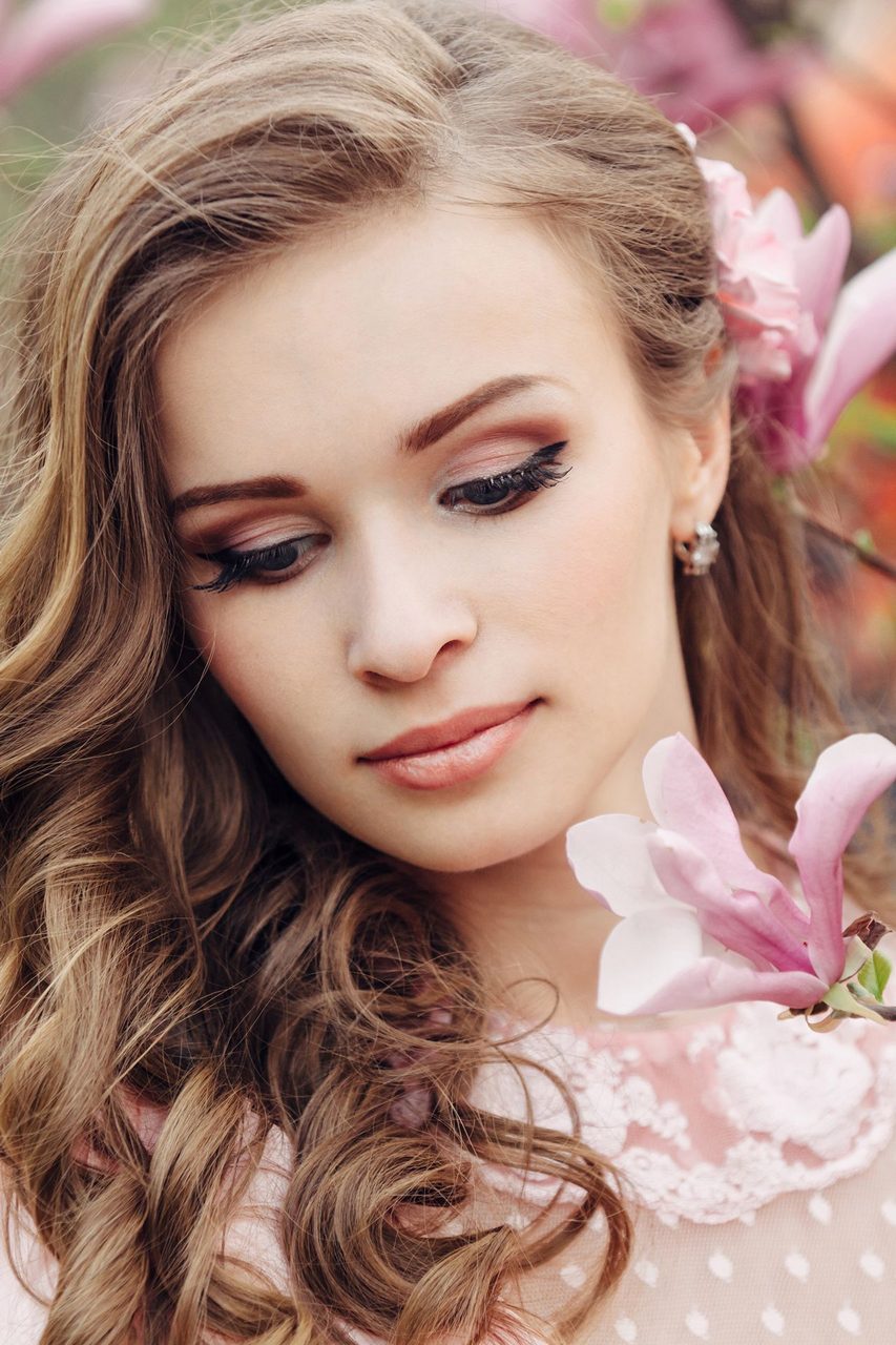 Sensual woman portrait in the blooming magnolia garden