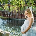 Beautiful pregnant woman on the walk outdoor near the house with lake